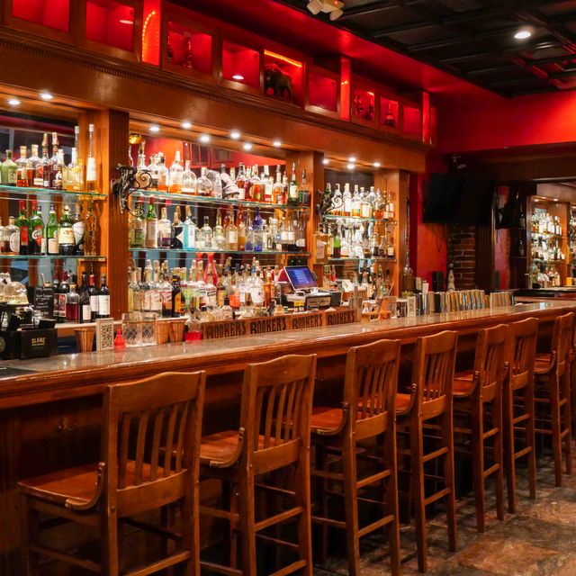 La Verdad bar interior with red lighting and wood bar